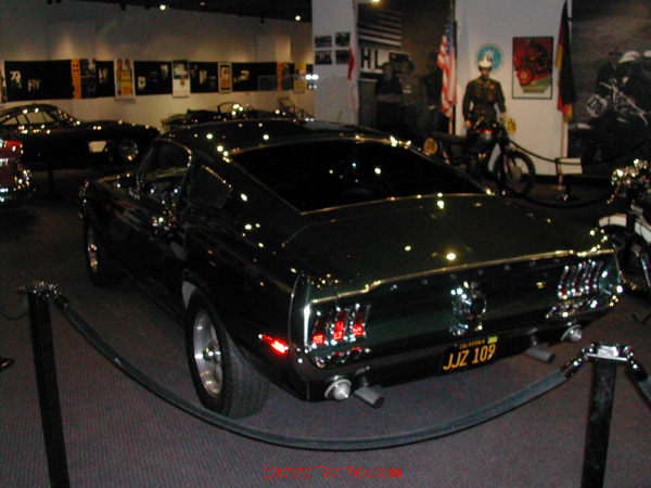 Fastback rear view of the BULLETT Mustang with more memorabilia in the background.