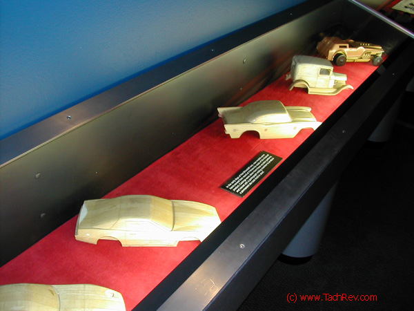 These wooden bucks on display have this information tag: "In the early days of Hot Wheels® cars, new models were hand-carved from wood at 4 times the scale of the finished product. Castings were taken from these wooden patterns, and traced with a pantograph milling machine to produce a permanent die-cast mold in steel."